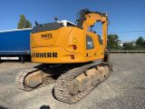 a yellow tractor that is parked next to a blue truck