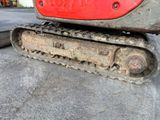 a close up of a red and black bulldozer on the ground