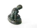 statue of a boy sitting on a rock with his head in his hands