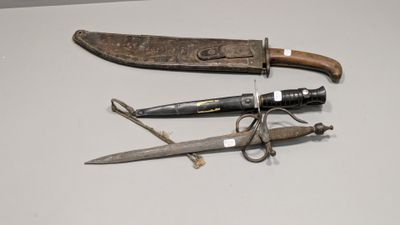Deux couteaux et une paire de ciseaux sont posés sur une table