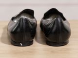 a pair of black shoes sitting on a wooden table