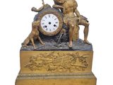 une horloge en or surmontée d'une statue représentant un garçon et un chien