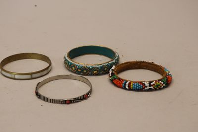 Trois bracelets différents sont posés sur une table avec un fond blanc.