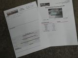 two papers with a picture of a car on them sitting on the ground