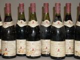 six bouteilles de vin sont alignées sur une table