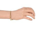 gold plated bracelet with a cross charm on a mannequin hand