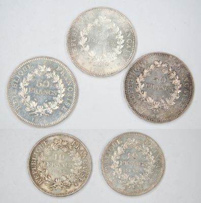 four different types of silver coins on a white surface