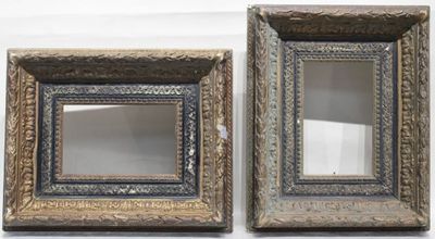 une paire de miroirs aux cadres ouvragés dorés et bleus sur fond blanc