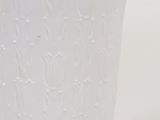 a white cup sitting on a table with a white background