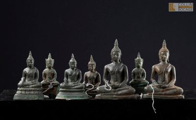 five statues of buddhas sitting in a row on a table