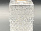 a clear glass bottle with a yellow lid
