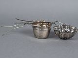 two silver spoons and a bowl on a gray surface