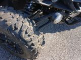 a close up of a four wheeler motorcycle parked in a parking lot