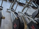 many stationary exercise bikes in a row in a gym