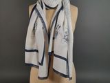 a white scarf with blue trims on a mannequin head