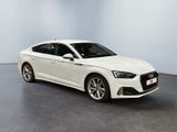 a white audi sedan parked in a room with a light blue wall