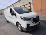 the white van is parked in a parking lot near a building