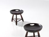 deux petits tabourets avec des pieds en bois et un assise noire