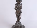 une statue en bronze représentant un jeune garçon tenant une fleur