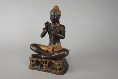 statue of a woman sitting on a rock playing a flute