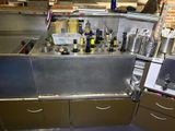 a kitchen with a sink and a lot of bottles on the counter