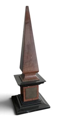 un obélisque en bois avec un socle noir sur fond blanc