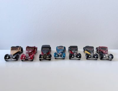 plusieurs petites voitures sont alignées sur une surface blanche