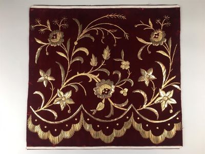 une tenture murale ornée d'un motif floral rouge et or
