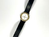 une montre posée sur une surface blanche