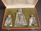 three glass salt and pepper shakers in a case