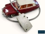 a red toy car with a white top and a cord attached to it