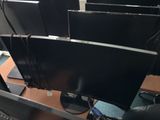 three computer monitors sitting on a desk with a keyboard and mouse