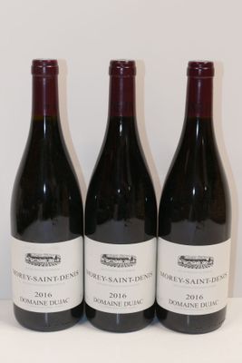 trois bouteilles de vin sont alignées sur une table