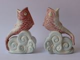 deux figurines d'oiseaux posés sur un nuage