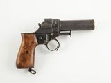 gros plan d'un revolver avec une poignée en bois sur une surface blanche