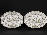 a pair of green and white plates with birds and flowers