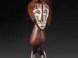 a small wooden figure of a man with a face painted on it
