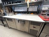 une cuisine équipée d'appareils électroménagers en inox et de plans de travail en inox