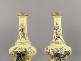 une paire de vases jaunes décorés d'oiseaux et de fleurs peints