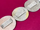 several coins are arranged in a row on a pink surface