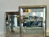 a large mirror sitting on the floor next to a chair