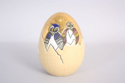 a wooden egg with an image of two birds on it
