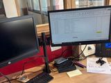 un bureau sur lequel sont posés deux écrans d'ordinateur et un clavier
