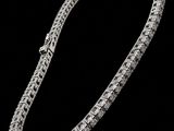 a diamond tennis bracelet on a black background