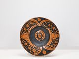 an orange and black plate sitting on top of a white table