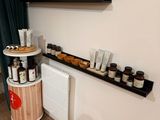 a shelf with jars and jars on it next to a radiator