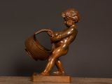 a statue of a boy with a bucket on a table