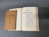 un livre ouvert posé sur une table, sur laquelle se trouve un autre livre