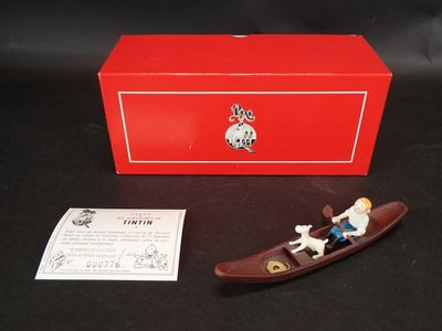 figurine représentant un homme dans un bateau avec un chien à bord et une boîte rouge