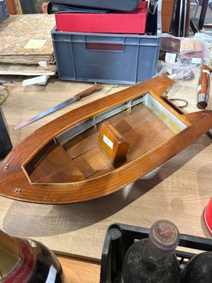 a wooden boat sitting on a table in a workshop
